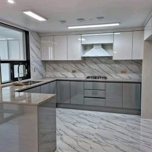 Custom kitchen design with glossy HDF cabinets and marble worktop from Winnyz Interiors