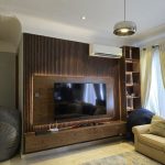 TV wall design with HDF wood, panels, and LED lights in a living room from Winnyz Interiors