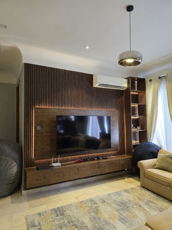 TV wall design with HDF wood, panels, and LED lights in a living room from Winnyz Interiors